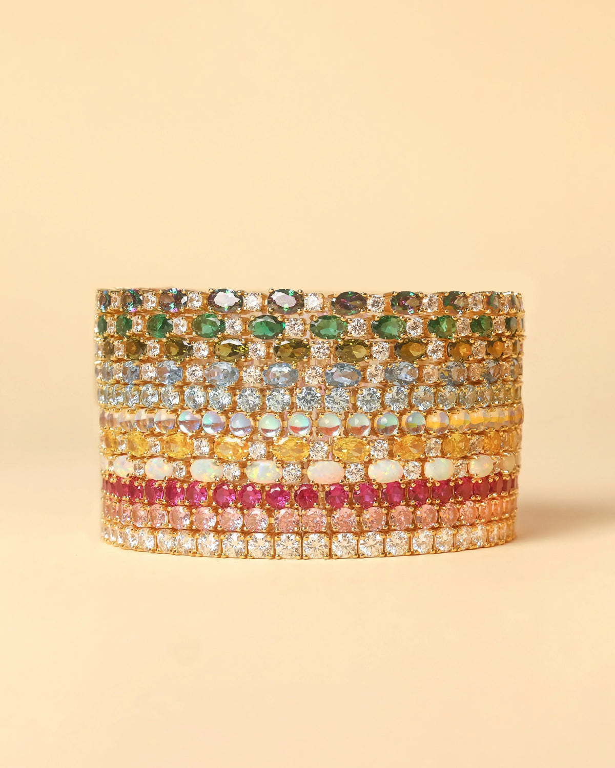 Stacked colorful gemstone rings in gold settings