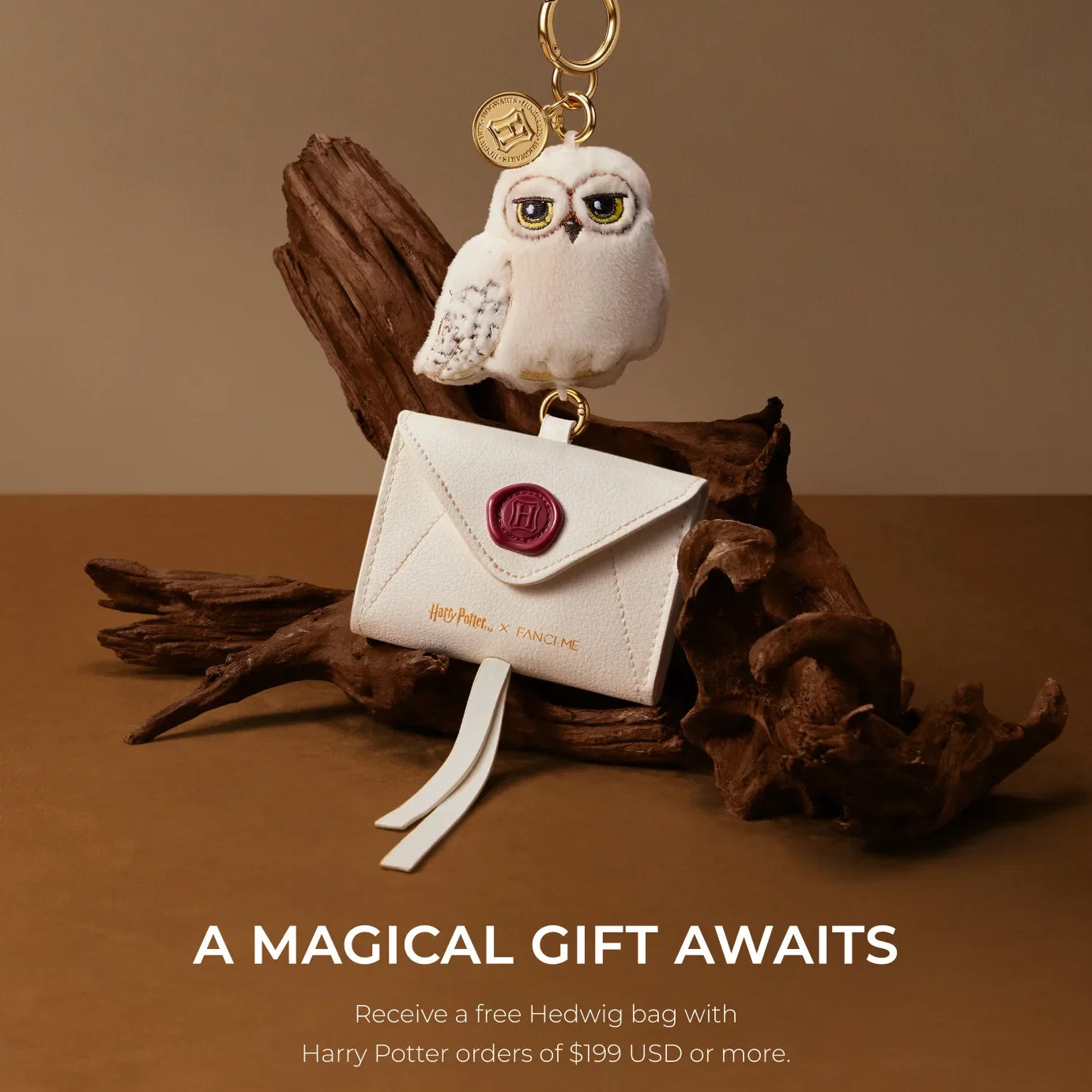 White Hedwig owl charm and envelope pouch on driftwood, with text 'A Magical Gift Awaits'