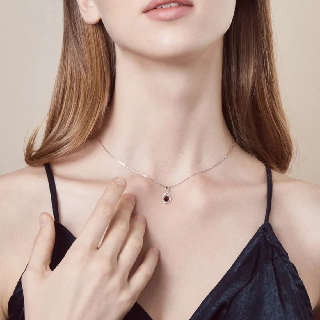 Close-up of a neck wearing two silver chain necklaces, the lower one with a star-shaped blue pendant.