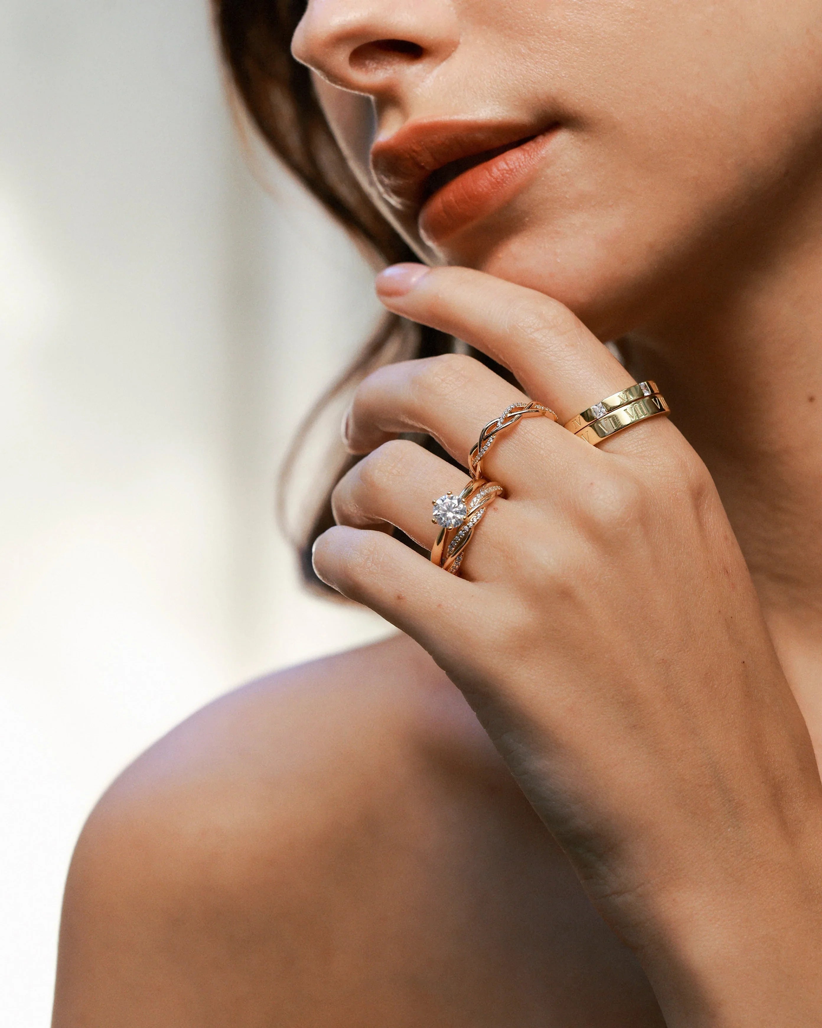 Close-up of a hand with three rings held near the chin